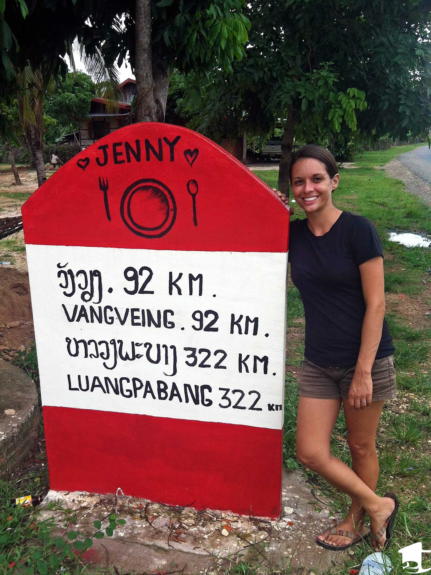 Tara next to a distance marker in Laos